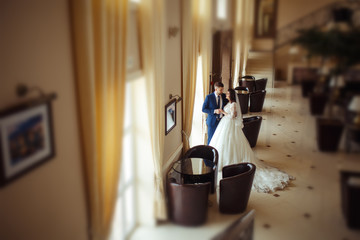 Beautiful Bride and Groom enjoy each other in the nice hall of the hotel. happy romantic young couple celebrating their marriage.Sexy kissing stylish couple of lovers close up portrait. wedding