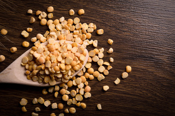 Сhopped peas in a wooden bowl on a wooden background near the ears of wheat. wooden spoon with chopped peas