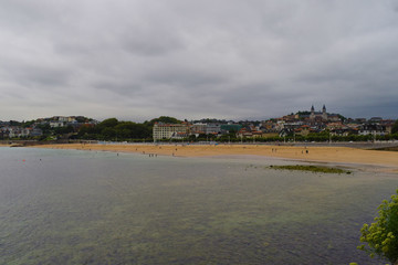 Playa y zona costera de una ciudad en un d&iacute;a nublado.