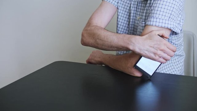 A man hands brings to the hand the smartphone for measuring glucose in the blood