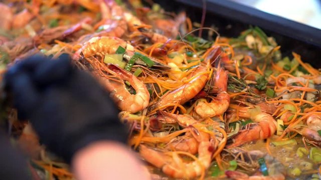 Cooking seasoned shrimp for chipotle shrimp tacos. Shrimp with parsley and lime in a frying pan cook mixes, closeup