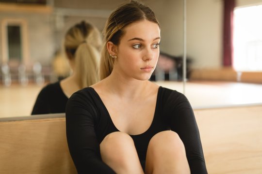 Young ballerina sitting on floor 