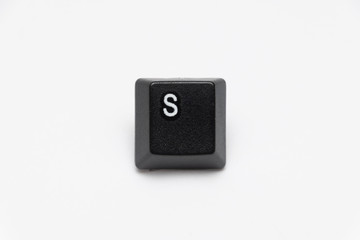 Single black keys of keyboard with different letters S