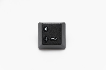 Single black keys of keyboard with different letters plus tilde