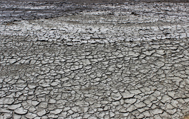 texture of the earth's surface and cracks next to the cold mud volcano. The layer of mud, which volcano erupts, quickly dries up and cracks covering with white mineral efflorescences. The Kerch