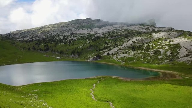 Flight by drone towards the mountain lake Sägistalsee in the Swiss Alps.