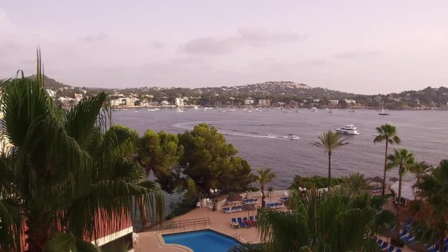 View over palm trees to boats in the bay at Santa Ponsa, Mallorca.