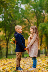 Fototapeta premium a loving couple of small children, a boy gives flowers to a girl, children's love, children's love story