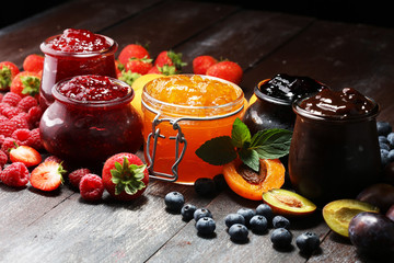 assortment of jams, seasonal berries, apricot, mint and fruits. marmalade or confiture