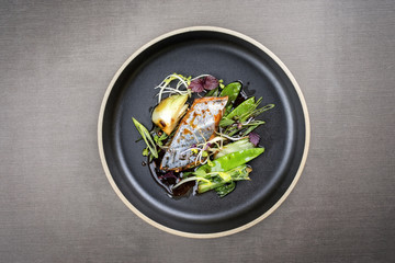 Modern style Japanese bonito tuna fish filet with vegetable glazed in teriyaki sauce as top view on a plate with copy space