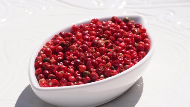 Dry spices pink pepper on a rotary table. 4K. Macroshooting.