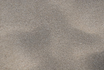 Textura o fondo de arena blanda seca de color beige claro en playa mediterránea Cala Ratjada, isla de Mallorca, Islas Baleares. Superficie o suelo arenoso limpio visto desde arriba.	