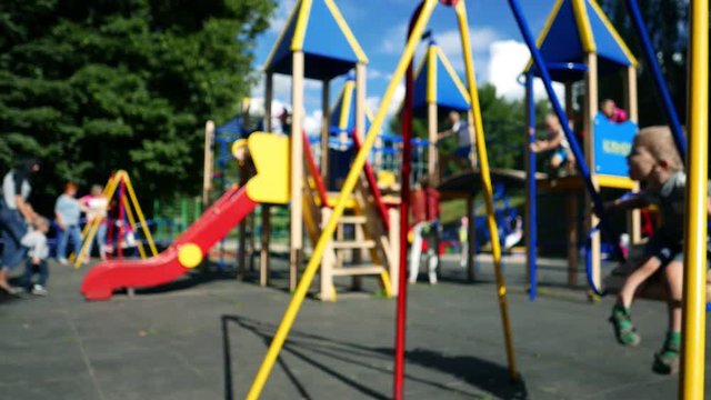 Children play on the playground, child kid boy on a swing 