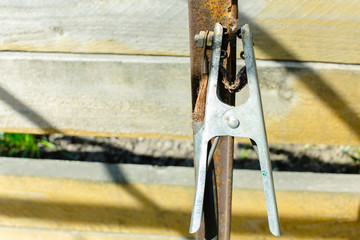 Clamp welder against the background of wooden fide