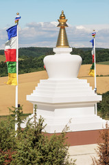 White stupa with multicolored flags - Buddhist symbol of Enlightenment, Europe, Poland; Stupa...