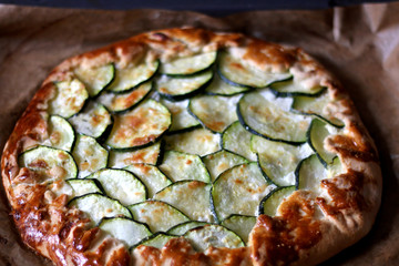 Galette made with courgette and cheese ricotta, mozzarella, parmesan. Top view, selective focus.
