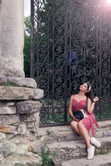 A girl in a dress sits on stone steps