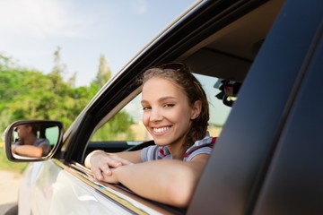 Fototapeta na wymiar Portrait of Smiling Young Woman in her Car