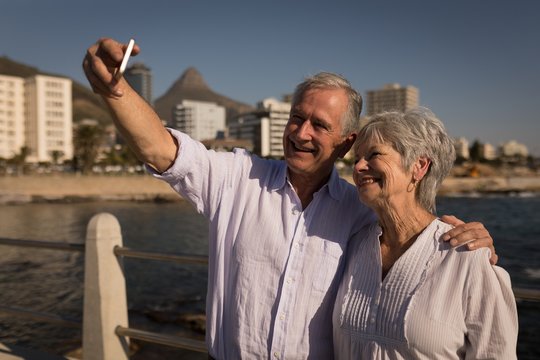 Senior Couple Taking Selfies At Promenade