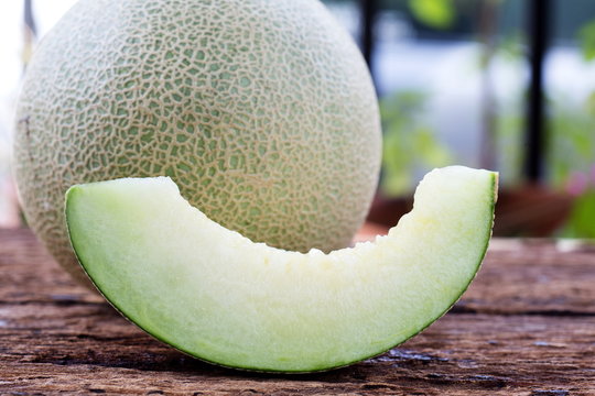 Sweet green melon on wooden table.