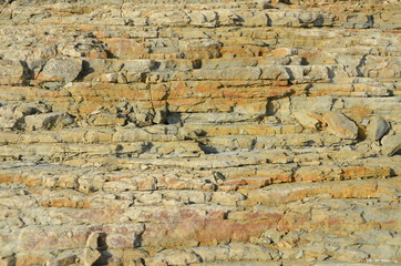 Natural rock structure background or texture. Lined rock with different natural colors.