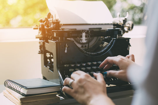 Woman's  hands writing on a vintage typewriter. Young woman writer at home, work on typewriter.