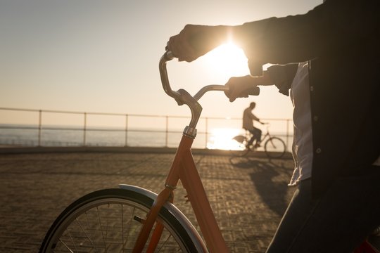 Senior woman holding bicycle at promenade