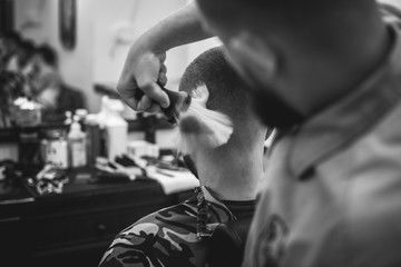Confident guy sitting at beauty salon . Man haircut. Soft focus.
