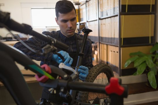 Man repairing bicycle in workshop