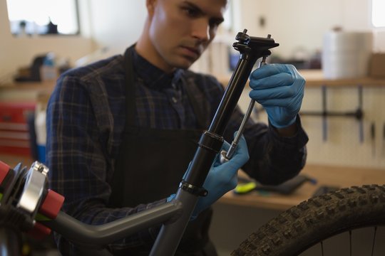 Man repairing bicycle seat in workshop