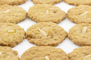 row of cookies with sliced almond on white background