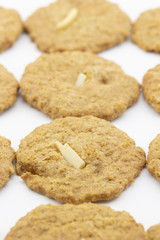 row of cookies with sliced almond on white background