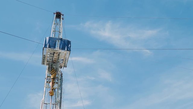Top Drive System (TDS) Spinning for Oil Drilling Rig at blue sky - Oil and Gas Industry.