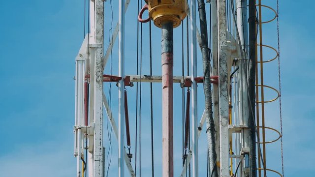 Top Drive System (TDS) Spinning for Oil Drilling Rig at blue sky - Oil and Gas Industry.