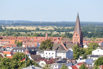 Village rooftops with wind turbines in the distance