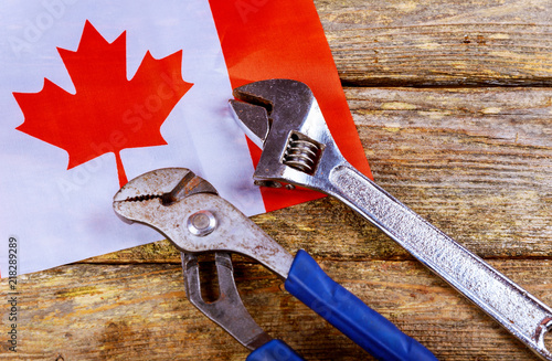 Labor day concept. canadian flag Different kinds on wrenches and wooden table.