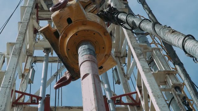 Top Drive System (TDS) Spinning for Oil Drilling Rig at blue sky - Oil and Gas Industry.