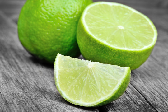 Lime with half on a gray rustic wood table