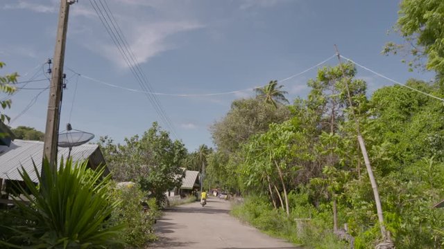 SLOW MOTION: POV walking along Thai seaside village road