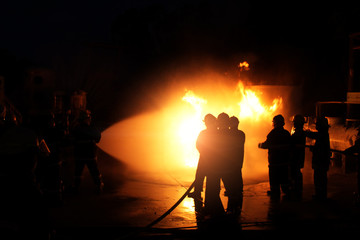 Fireman training Spray water curtain for helped stop the fire. Fire in the Industrial Factory . Rescue ,Education ,Emergency and Teamwork concept .