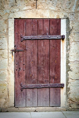 Medieval castle wooden door with massive iron hinges.