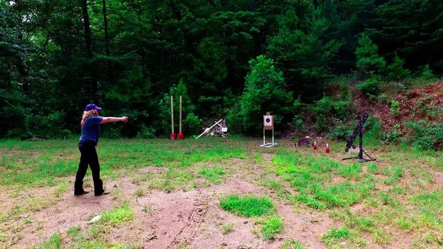 Woman practicing at outdoor pistol target range