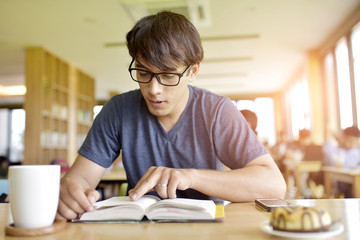 A young man likes coffee. Read books in cafes.