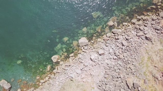 Overhead view of beautiful clear ocean water and rocks at Torquay, England.