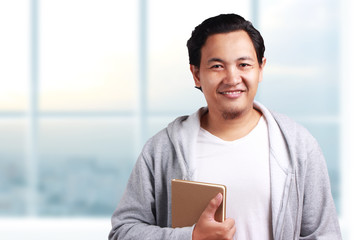 Young Man Holding a Book, Smiling Expression