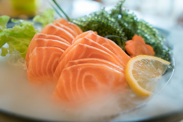 Raw salmon slice or salmon sashimi in Japanese style fresh serve on ice in bowl.