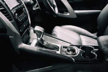 Fototapeta na wymiar Luxury of car interior at transmission shift gear area. Modern car interior, gearstick radio and cup holder..
