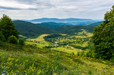 beautiful countryside landscape in mountains. forested hills and village down in the valley....