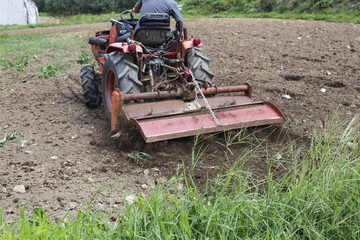 Farmer in tractor preparing land for sowing