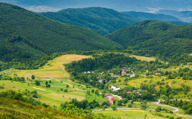 Fototapeta na wymiar village in the valley. view from the top of a hill. beautiful summer scenery in mountains